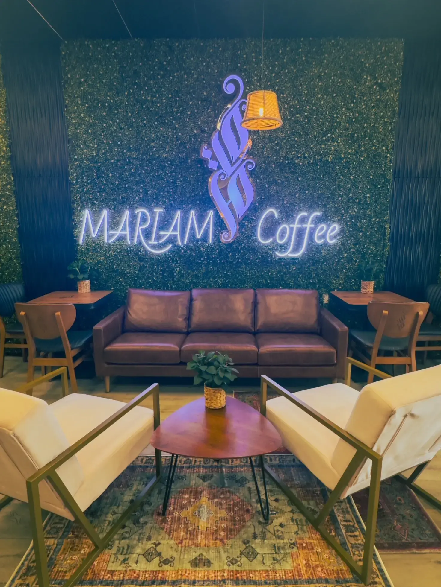 Mariam Coffee neon sign and cozy lounge area